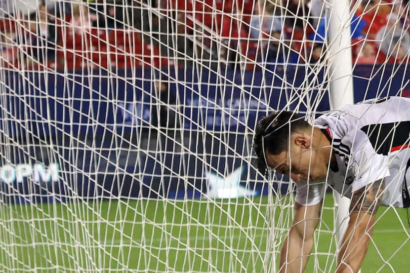 FC Dallas attacker Petar Musa (9) reacts as he grabs the webbing inside an empty goal after...
