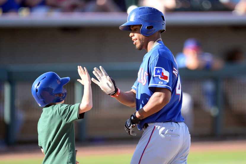 Mar 15, 2014; Phoenix, AZ, USA; Texas Rangers outfielder Nick Williams slaps hands with a...