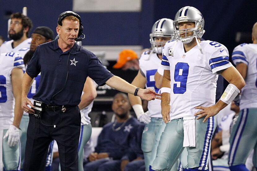 Dallas Cowboys head coach Jason Garrett gives a tap to quarterback Tony Romo (9) on the...