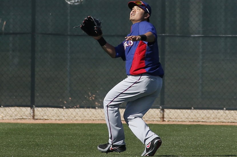 Texas outfielder Shin-Soo Choo practices playing a fly ball in the sun during Texas Rangers...