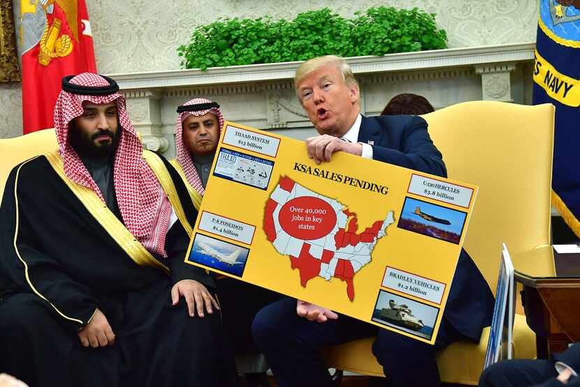 President Donald Trump holds up a chart of military hardware sales as he meets with Crown...