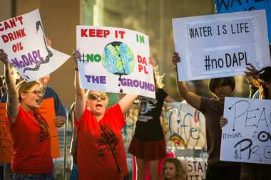 Marjoe Sweatt chants with other activists as they picket outside the corporate offices of...