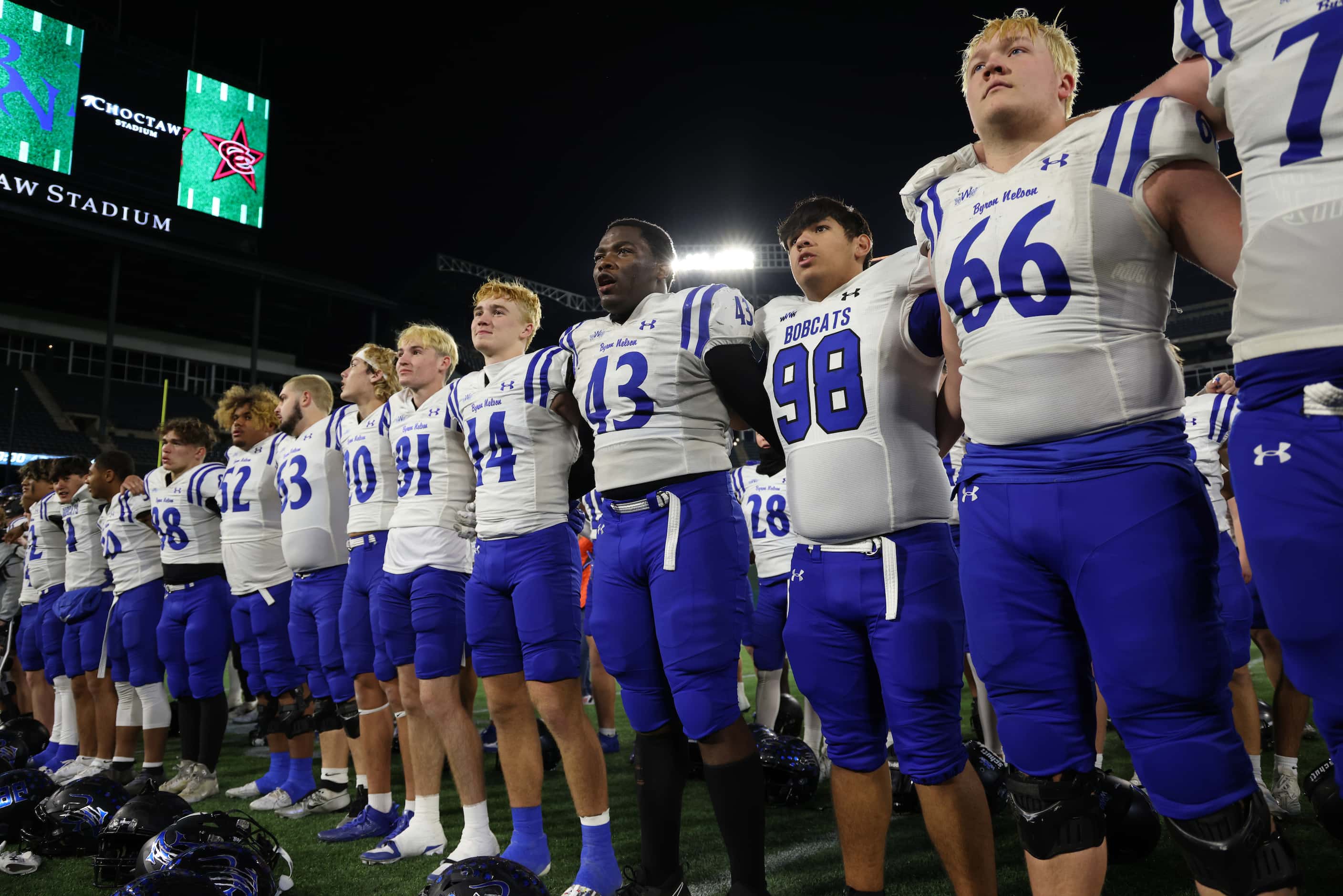 Byron Nelson players pause for the playing of the school song following their 52-45 victory...