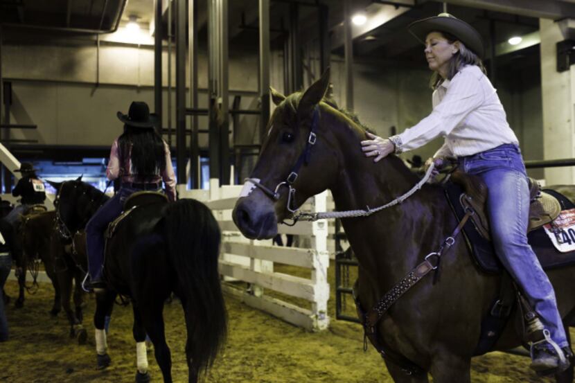 Cathy Grant pats her horse before their barrel-racing run at the Fort Worth Stock Show & Rodeo.