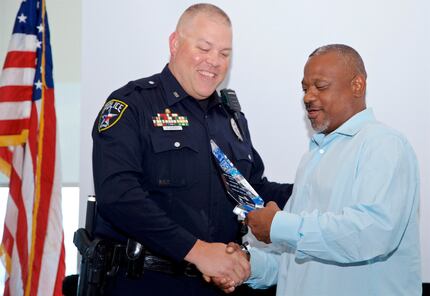Robert White, a TxDOT traffic safety specialist, presents Irving police Officer Stephen...