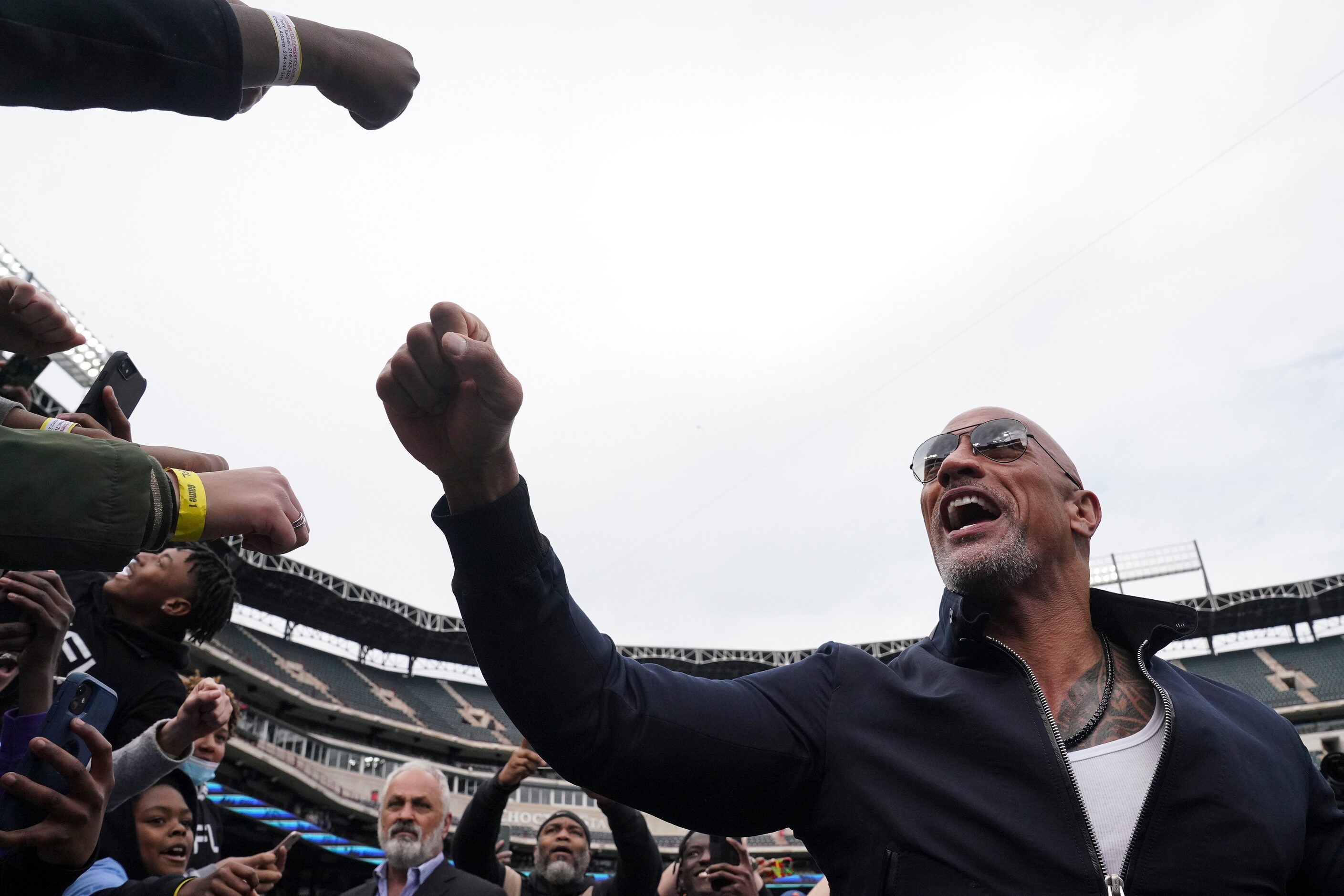 Dwayne “The Rock” Johnson fist bumps kids in the crowd before an XFL football game between...