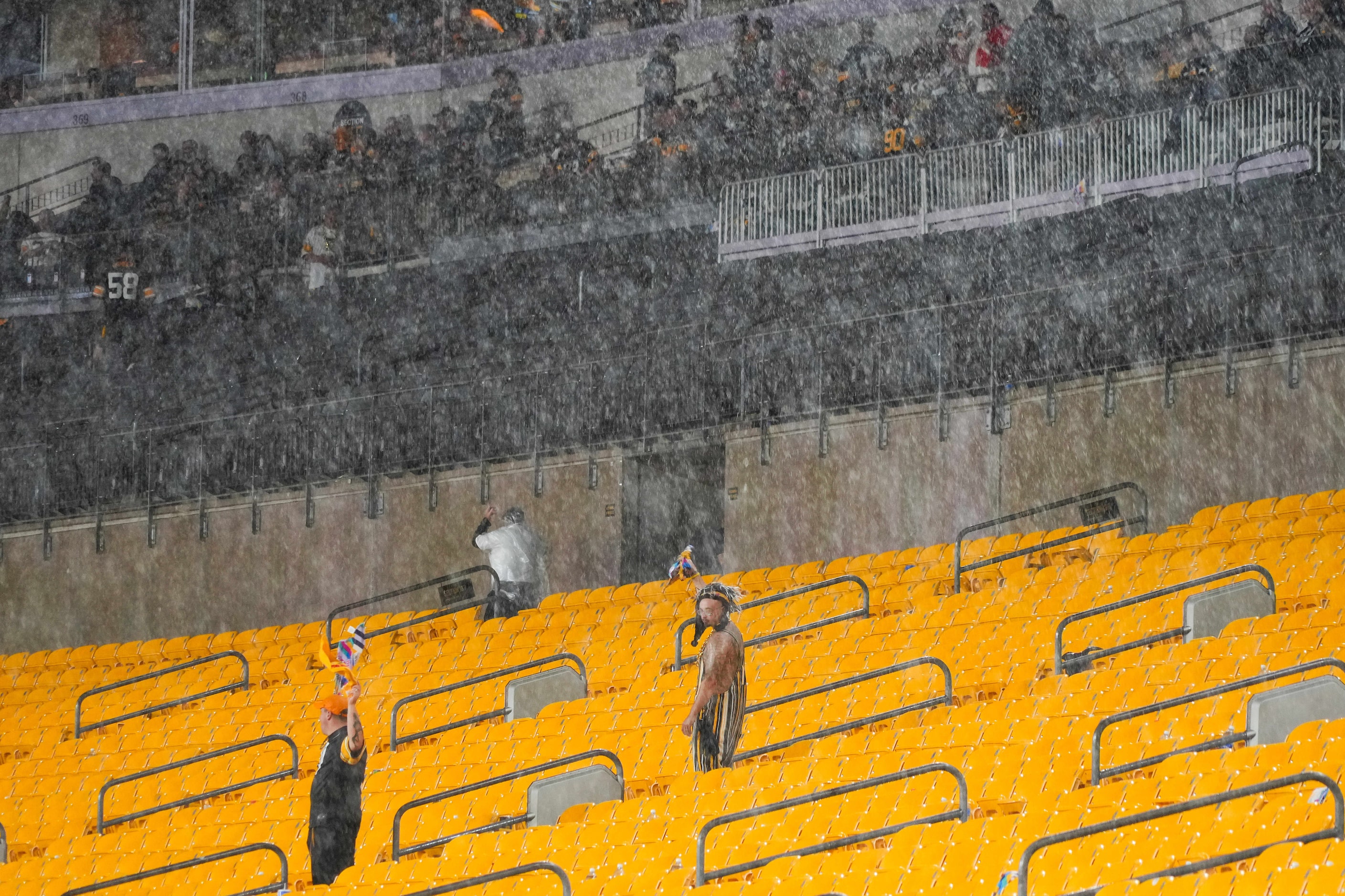 While most fans heed stadium officials’ calls to move under covers a few brave the elements...