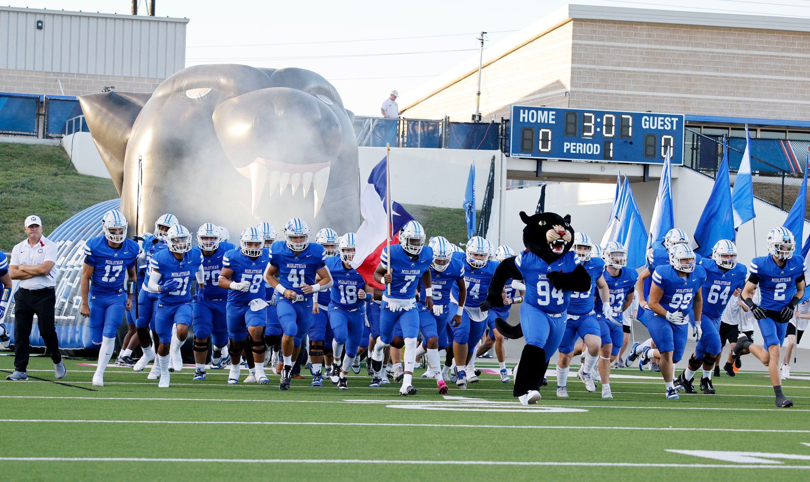 Midlothian players run into the field before a high school football game against...