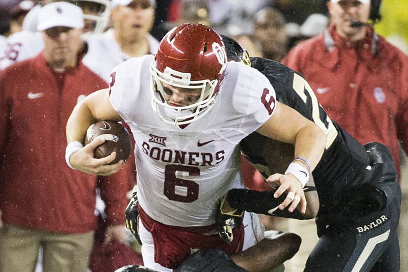 Oklahoma Sooners quarterback Baker Mayfield (6) is pushed out of bounds by Baylor Bears...