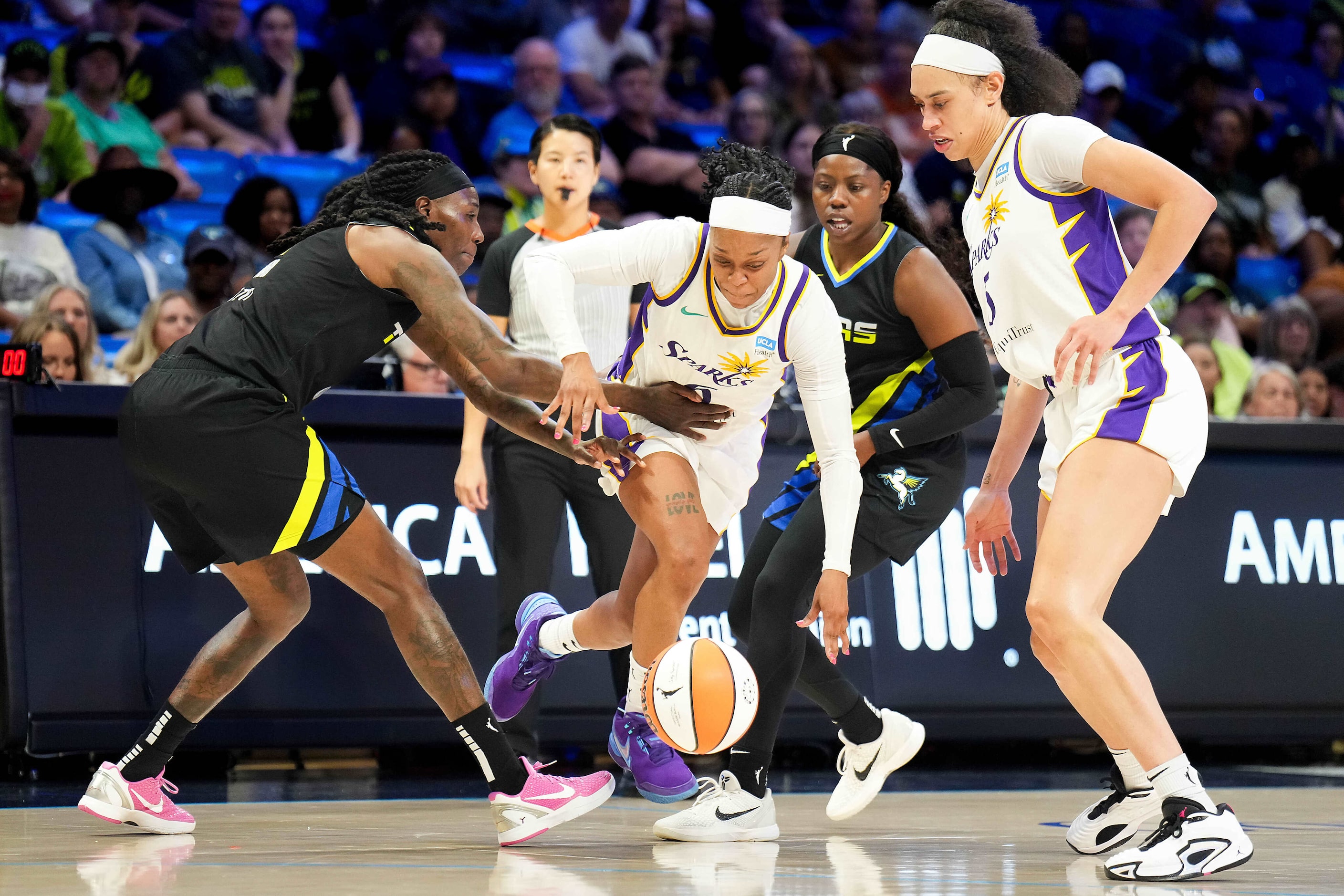 Los Angeles Sparks guard Odyssey Sims loses the ball as she tries to drive between Dallas...