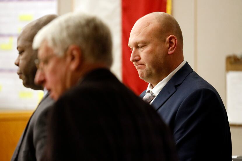 Former Dallas police officer Christopher Hess (right) and his attorneys convene before a...