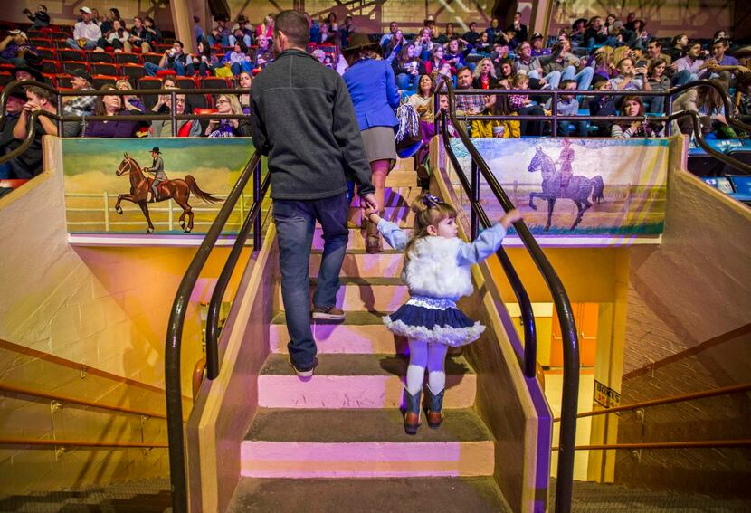 
Audience members make their way to their seats between hand-painted murals that hang over...