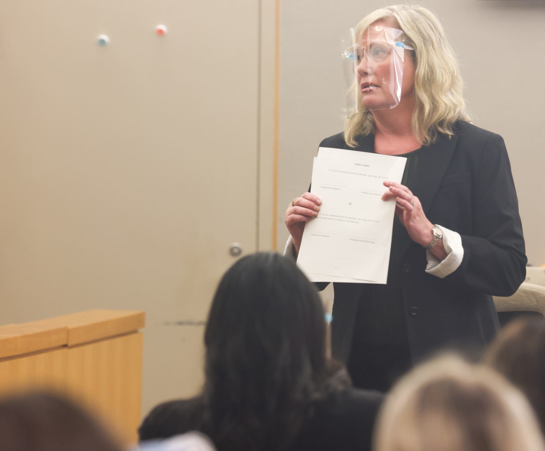 Prosecution lawyer Brandi Mitchell holds a copy of the verdict forms as she speaks to the...
