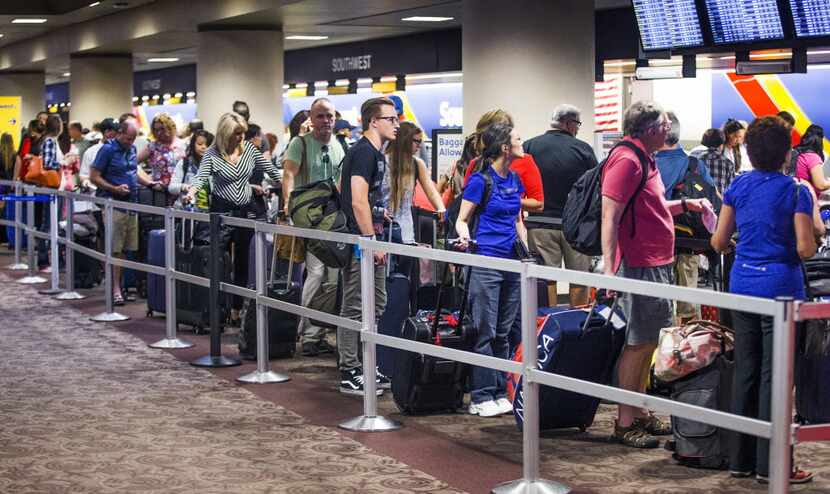 In this July 21, 2016, file photo, people wait in the Southwest Airlines check-in line at...
