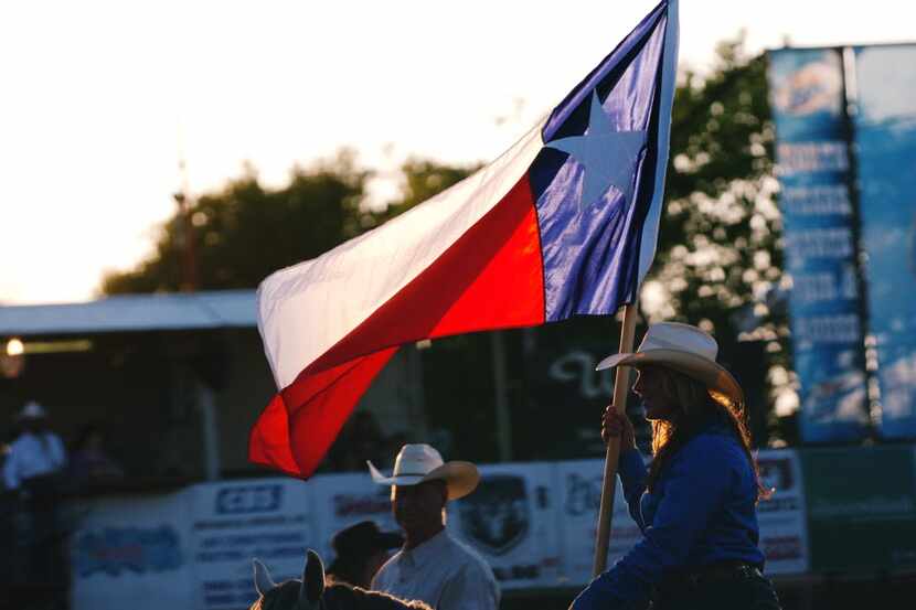 The Texas flag waved in the evening sun at the start of rodeo action at the 2013 North Texas...