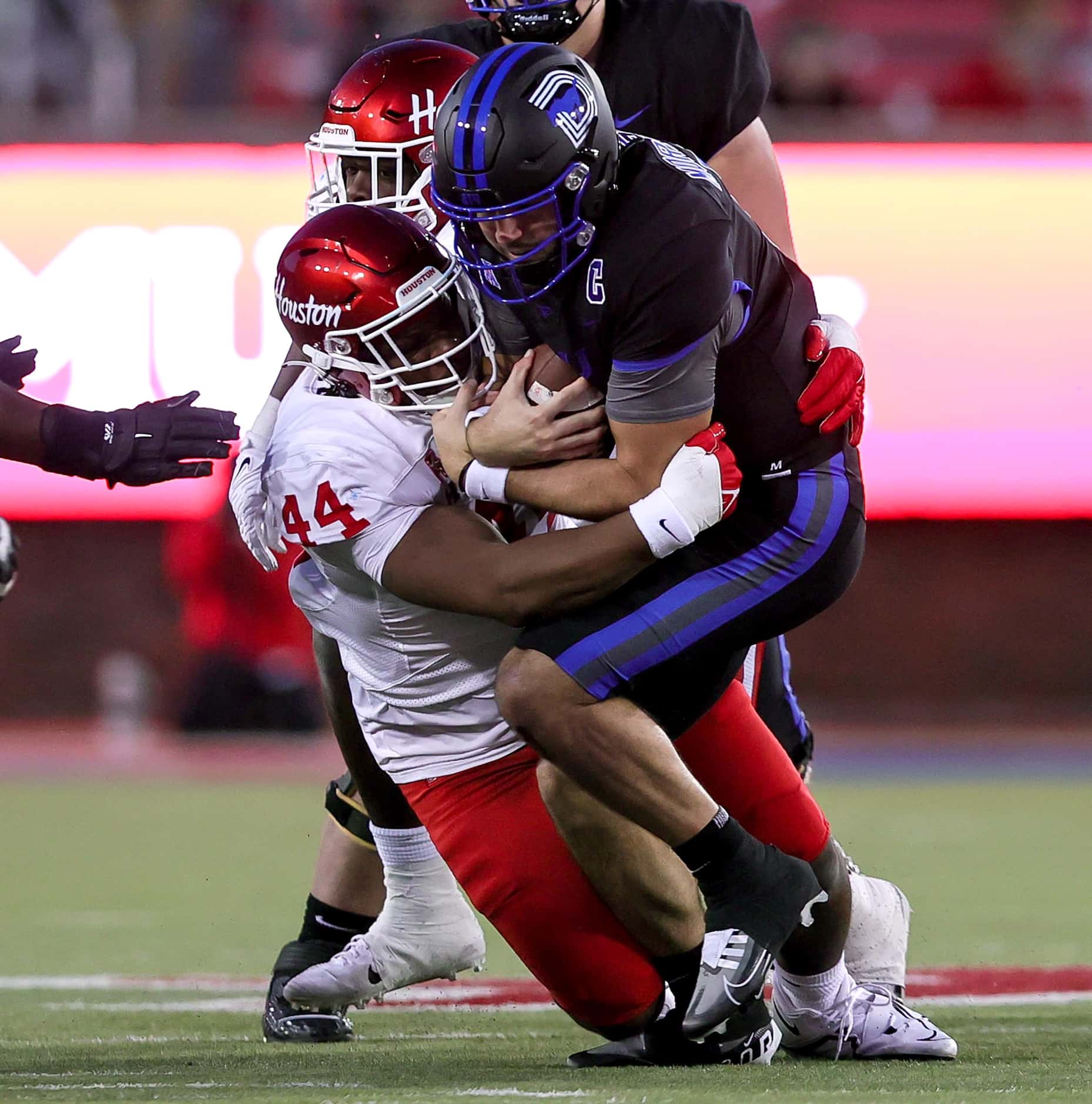 SMU quarterback Tanner Mordecai (right) gets sacked by Houston defensive lineman D'Anthony...