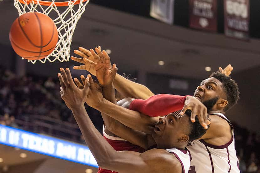 Texas A&M's Emanuel Miller (5) and Josh Nebo (32) vie for a rebound against Arkansas' Adrio...