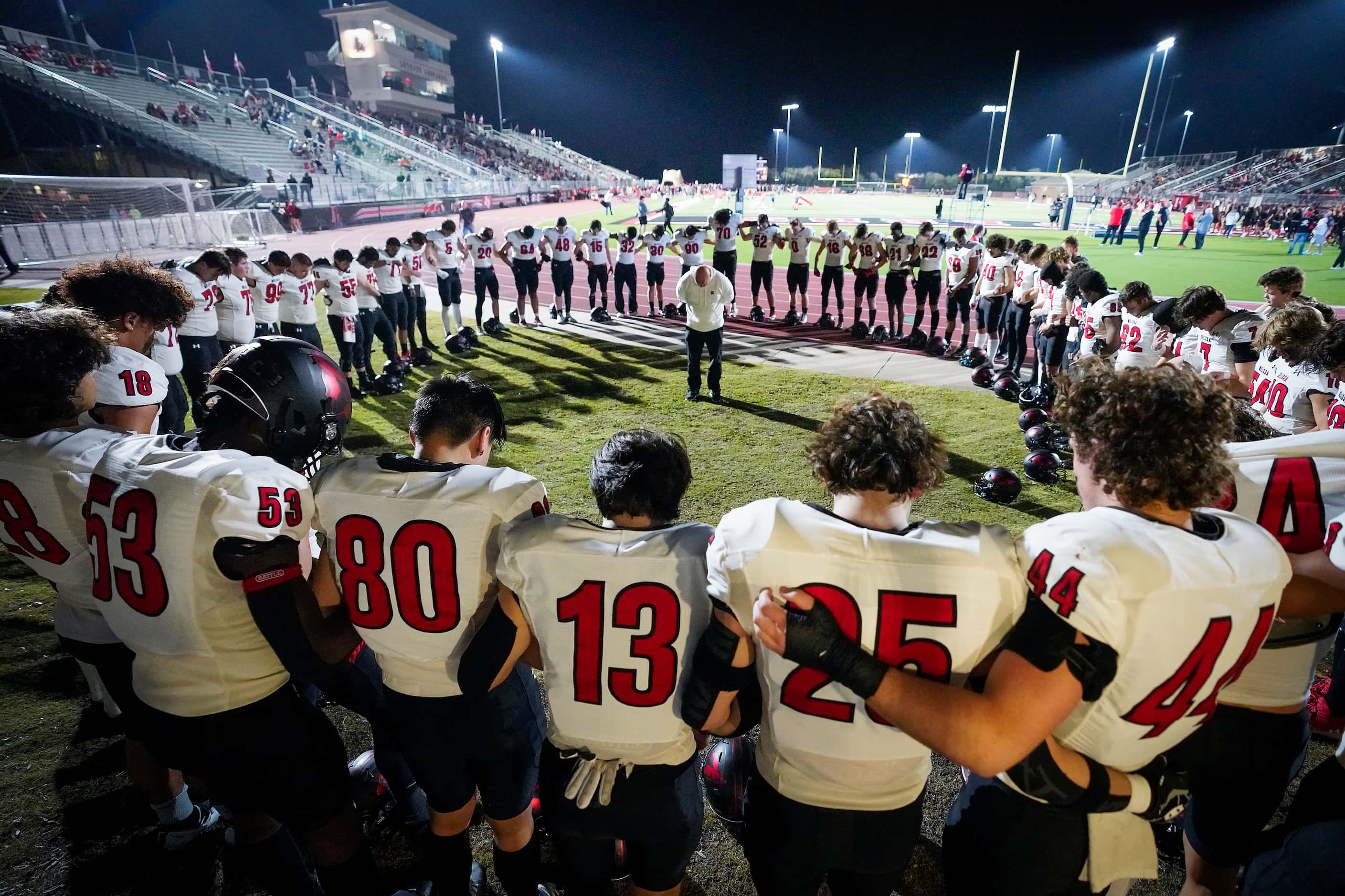 Melissa players circle in prayer before taking the field to face Lovejoy in a District 7-5A...