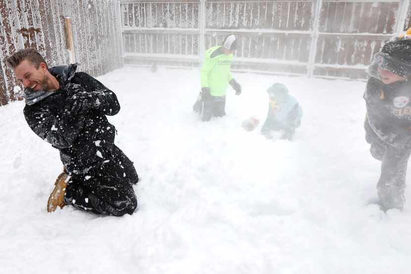 Jeramy Melchiorre, left, gets hit with a snowball thrown by his son, Christian Melchiorre,...
