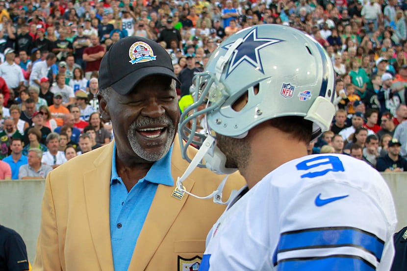 Dallas Cowboys Hall of Famer Rayfield Wright shakes hands with Cowboys quarterback Tony Romo...