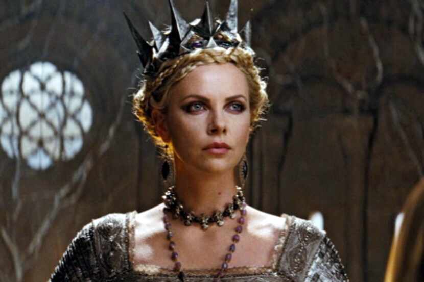 Charlize Theron disfrazada de reina, con una corona plateada.