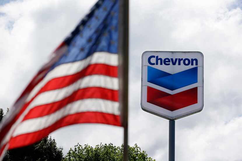 FILE - In this May 23, 2013, file photo, a United States flag flies in view of a Chevron gas...