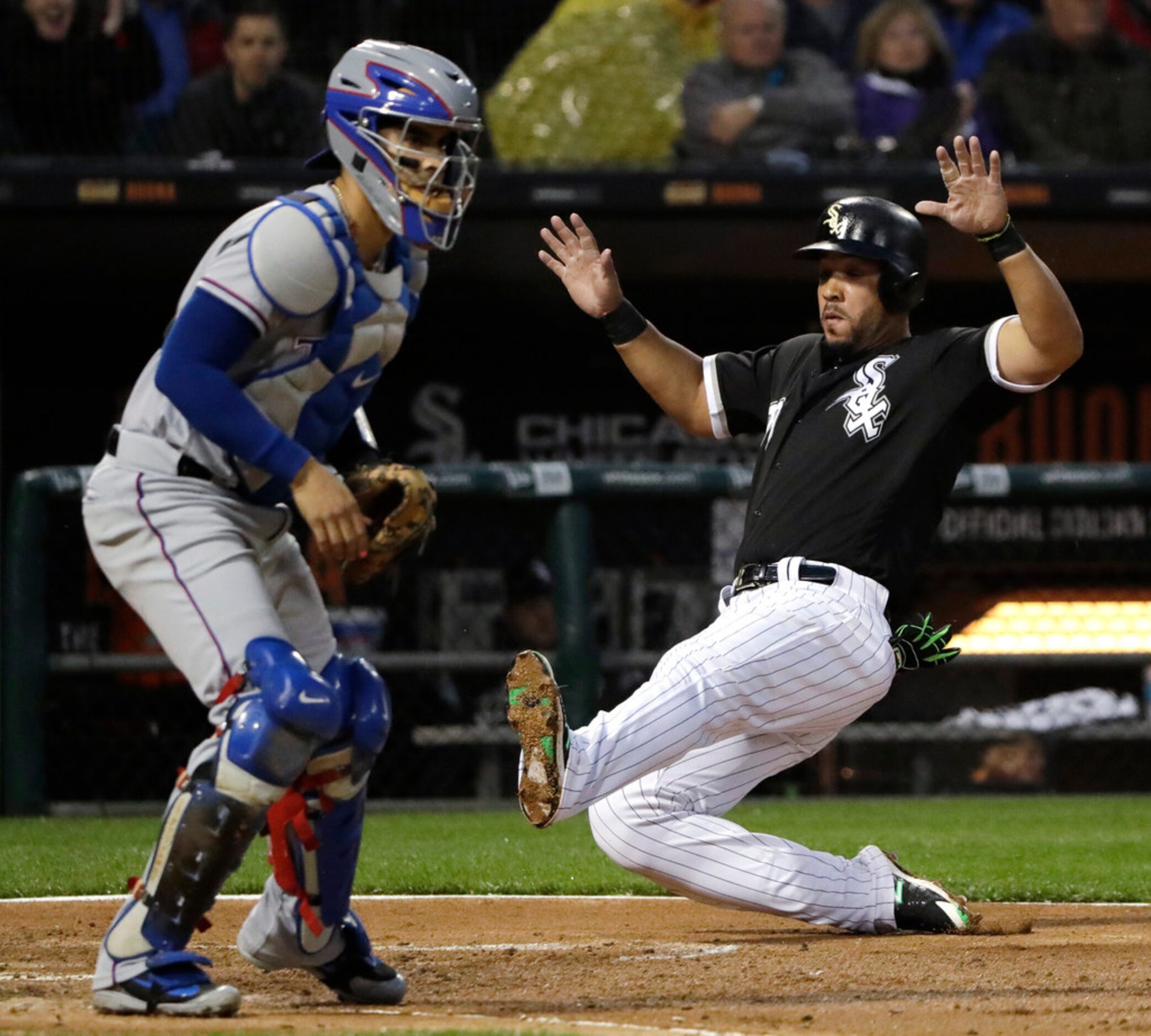 Chicago White Sox's Jose Abreu, right, scores as Texas Rangers catcher Robinson Chirinos...