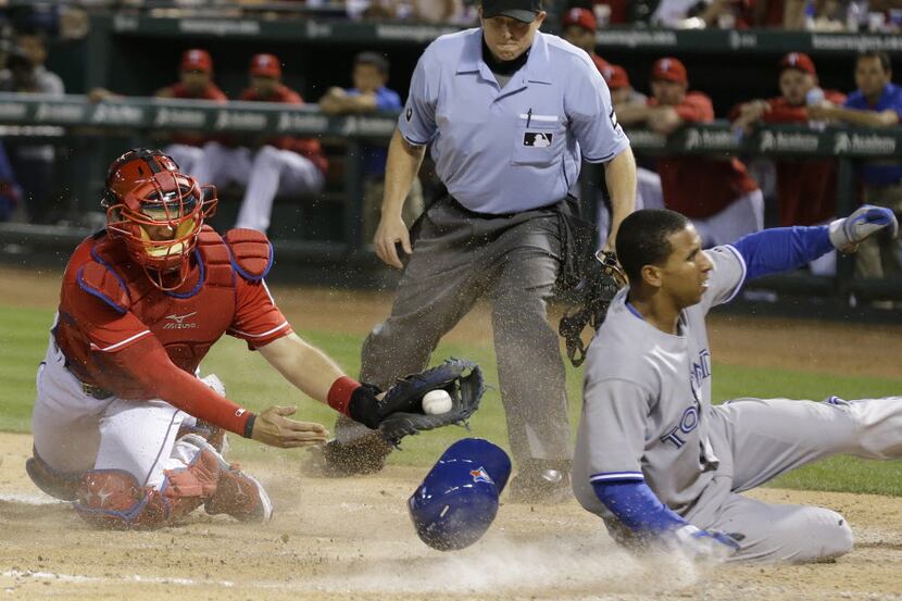 Toronto Blue Jays Anthony Gose, right, slides into home plate beating the tag of Texas...