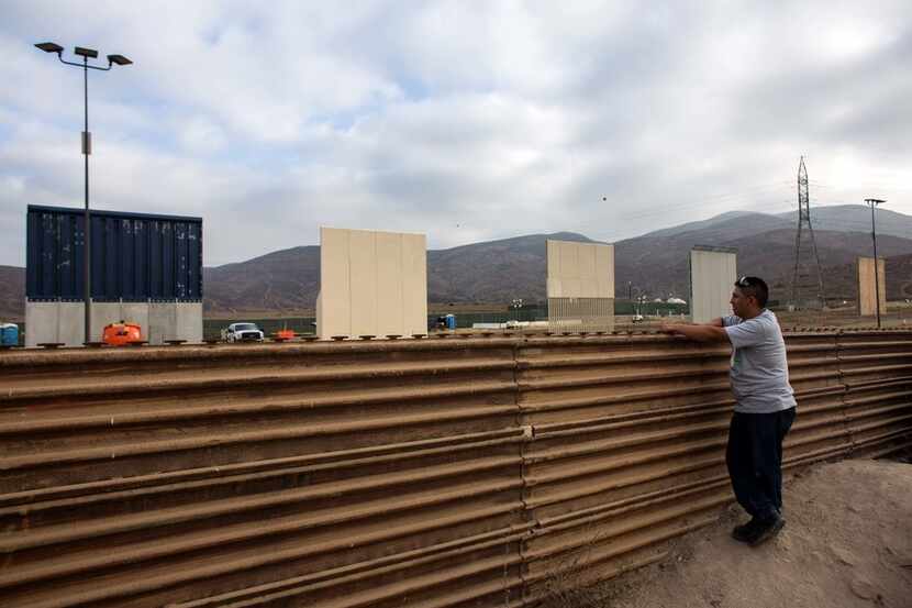 A man in Tijuana, Mexico, watches across the border as a prototype of President Donald...