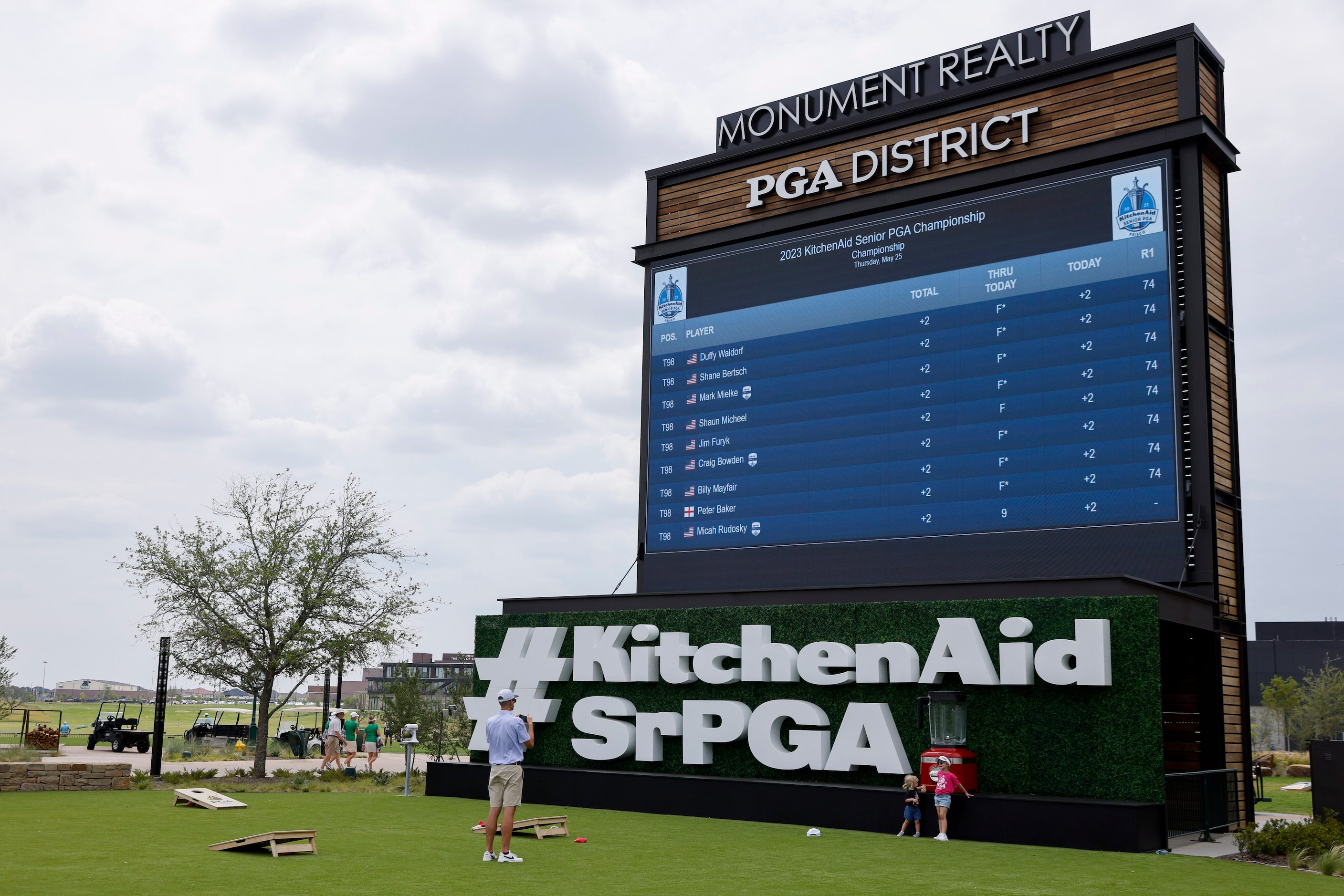 People take pictures in front of a leaderboard during the first round of the 83rd KitchenAid...