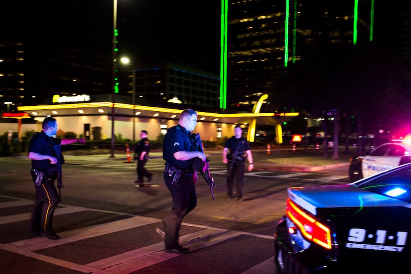 Dallas police walk through the intersection of Griffin and Jackson in downtown Dallas after...