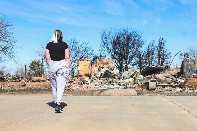Bailey Barnes examines what is left of her parent's, Brent and Rachel Clapp, home on...