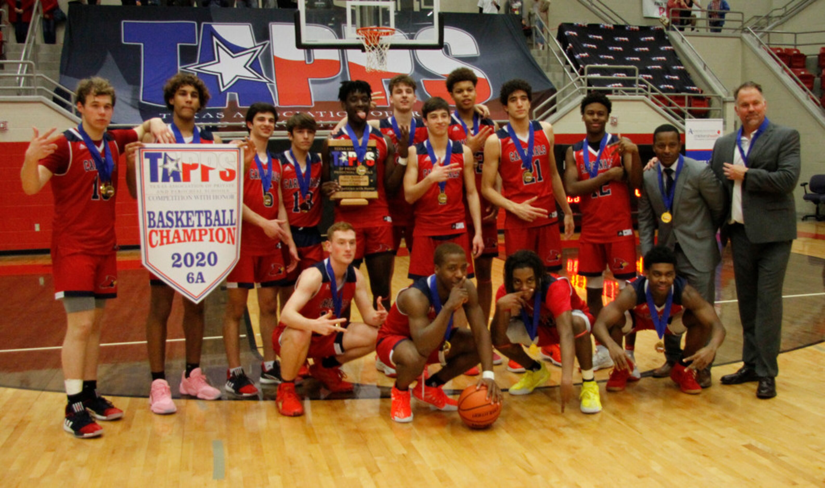 Members of the Plano John Paul ll boys basketball team pose after defeating San Antonio...