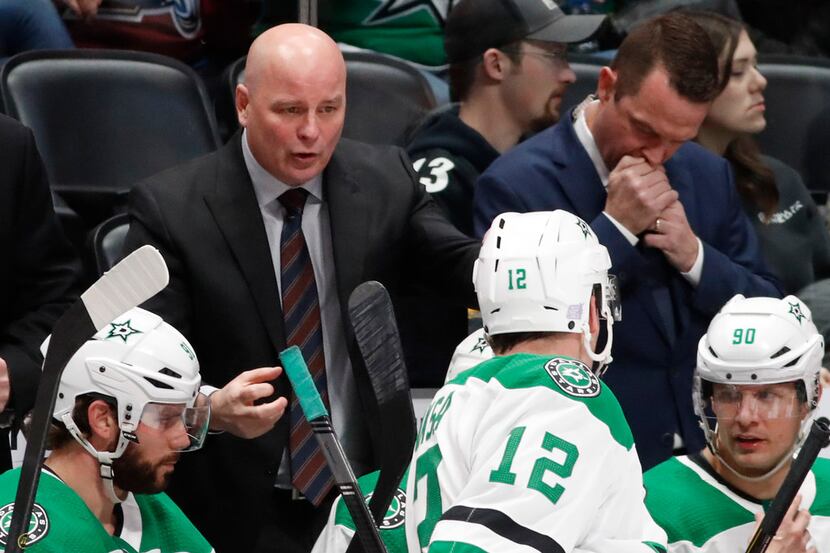 Dallas Stars head coach Jim Montgomery, back, confers with center Radek Faksa during a...