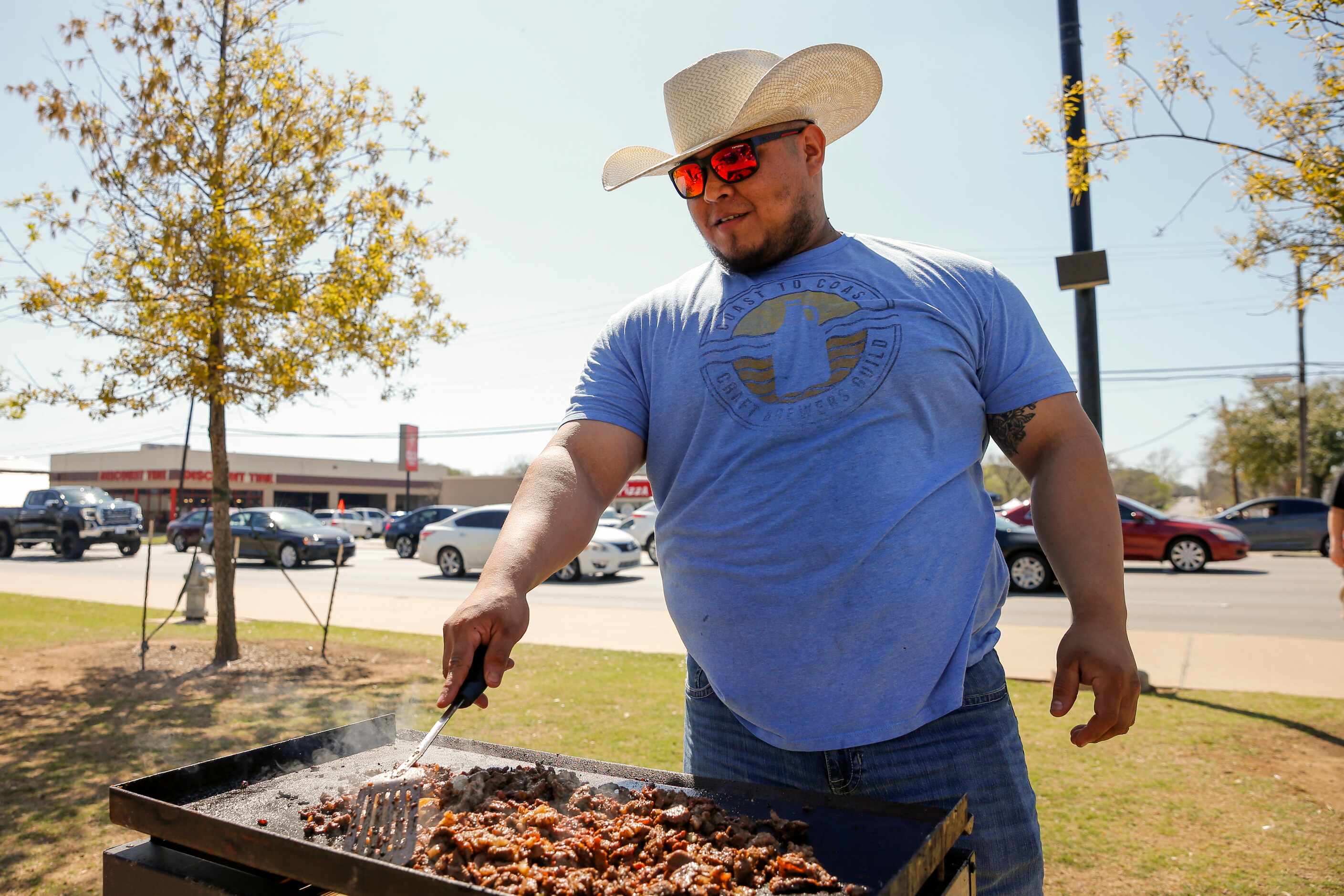 Mauricio Vargas, 29, of Midloathian, Texas tends to his grill while tailgating before...