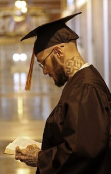  Warren Bishop reads a Bible before entering the chapel during the commencement. He is one...