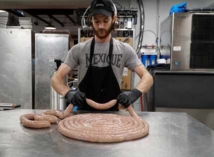 In this late 2020 photo, a Hurtado Barbecue employee prepares Thanksgiving sausage. In its...