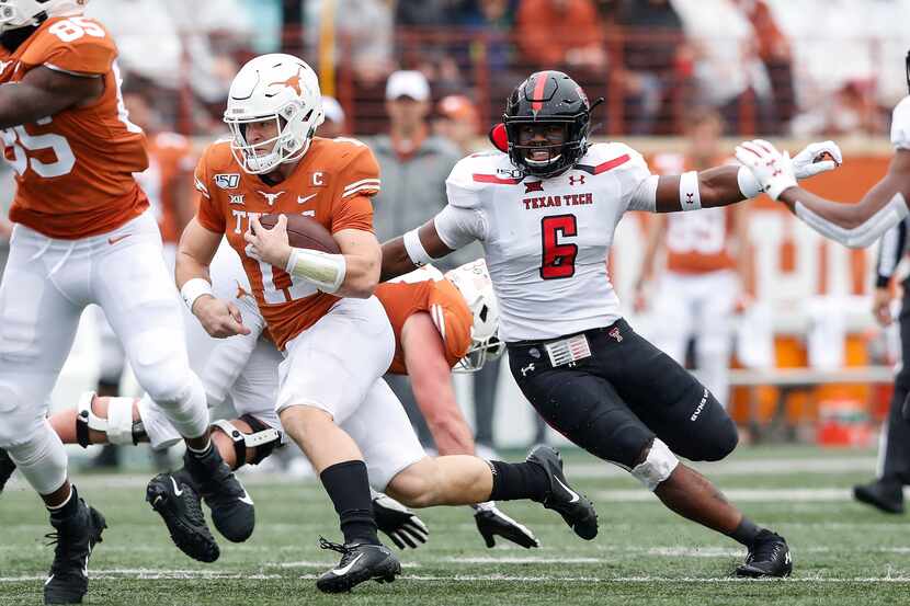 Sam Ehlinger #11 of the Texas Longhorns runs the ball defended by Riko Jeffers #6 of the...