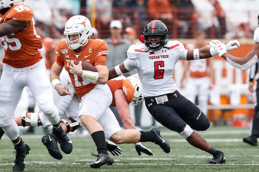 Sam Ehlinger #11 of the Texas Longhorns runs the ball defended by Riko Jeffers #6 of the...