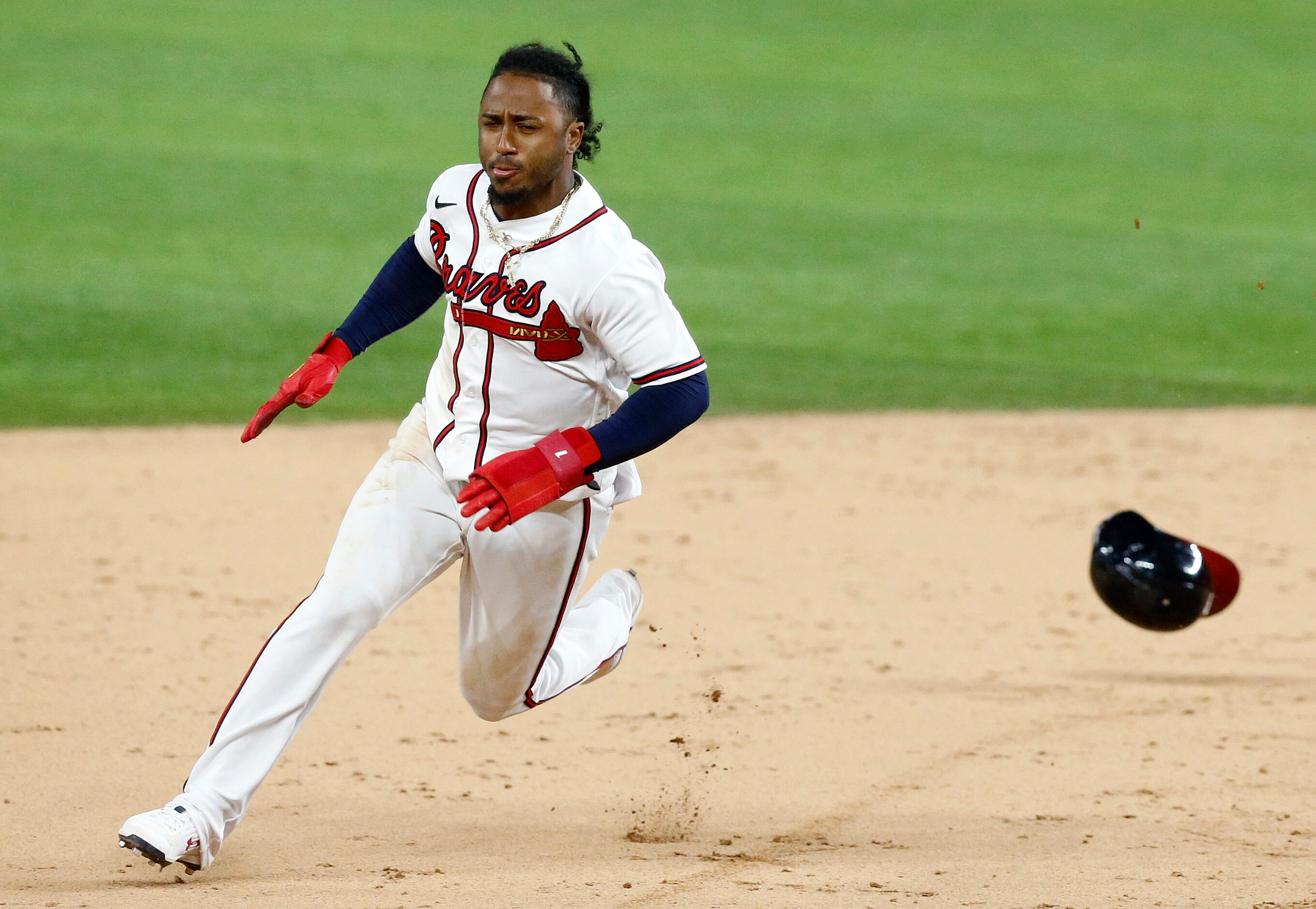 Atlanta Braves second baseman Ozzie Albies (1) looses his hemet rounding second base as...