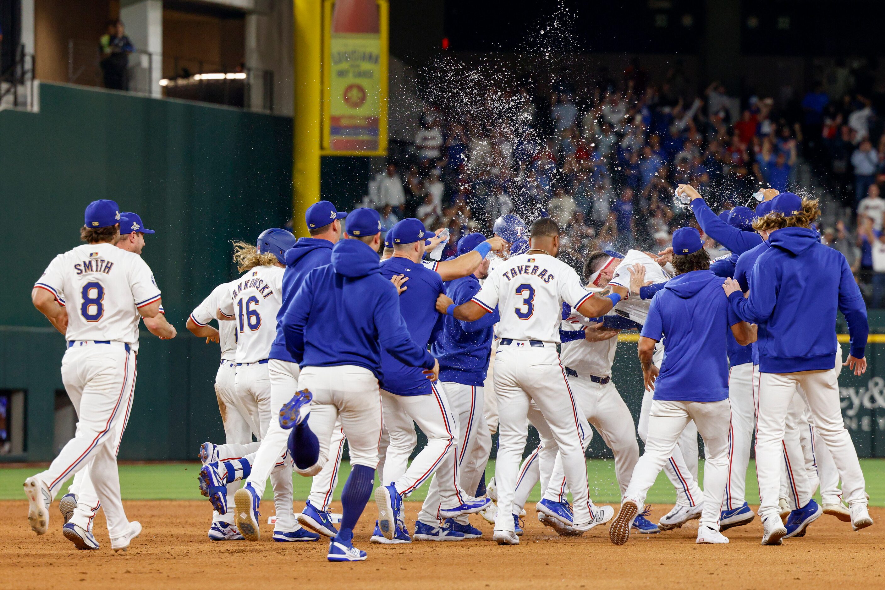 The Texas Rangers celebrate the game-winning hit by catcher Jonah Heim during the 10th...