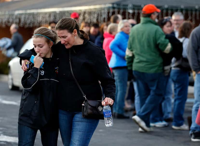 A parent picks up her daughter at a church where students from nearby Arapahoe High School...