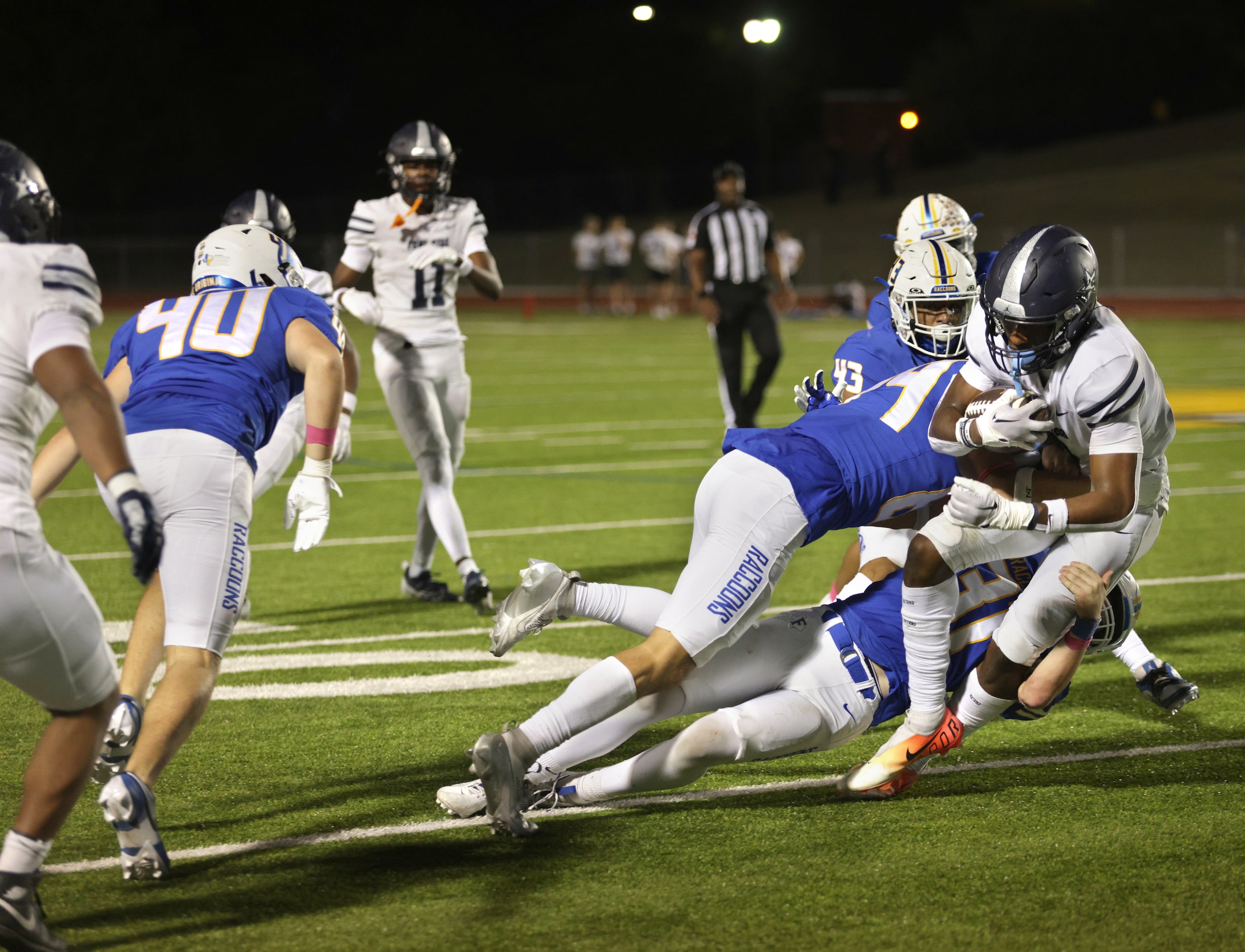 Lone Star player #0 Davian Groce is taken down by several Frisco players during the Frisco...