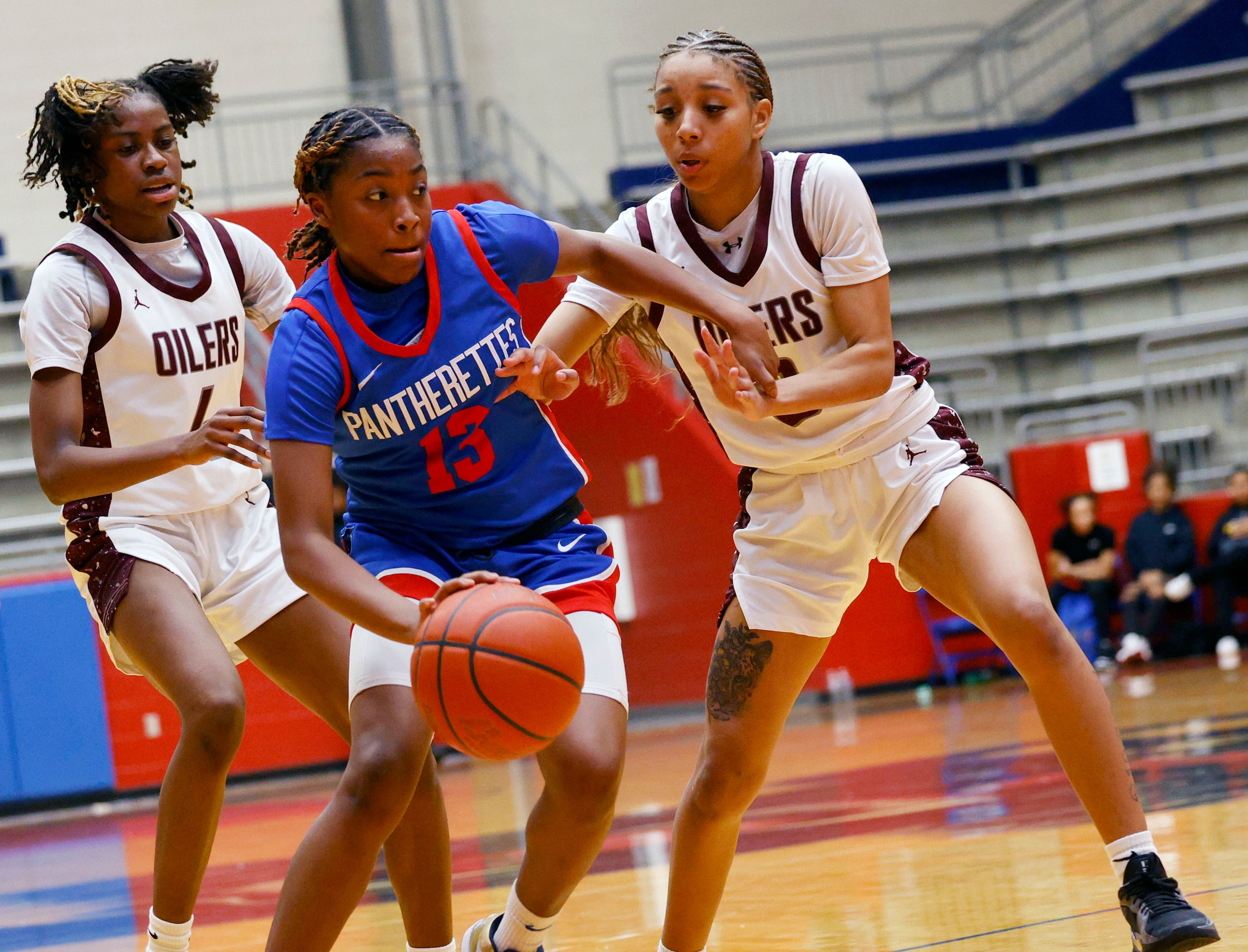 Duncanville's Samari Holmen (13) keeps the ball away from Pearland's Shiloh Grays (4) and...