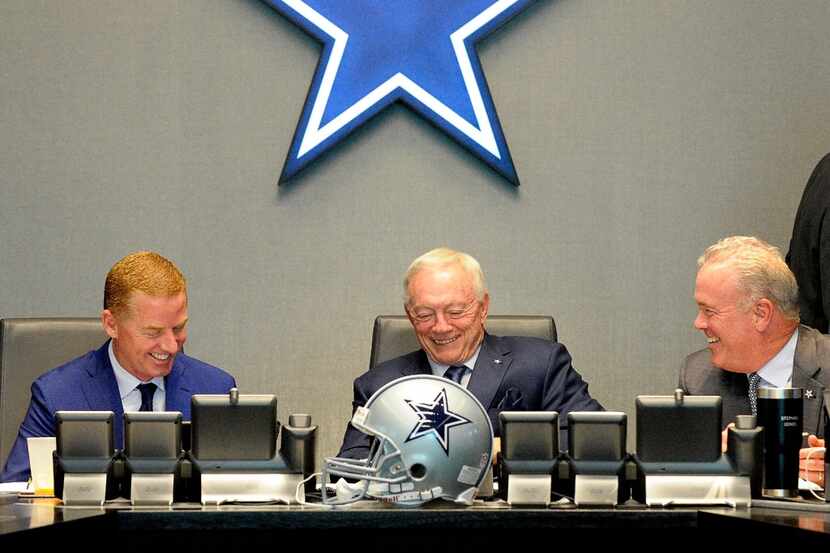 Dallas Cowboys owner Jerry Jones, center, talks with head coach Jason Garrett, left, and...