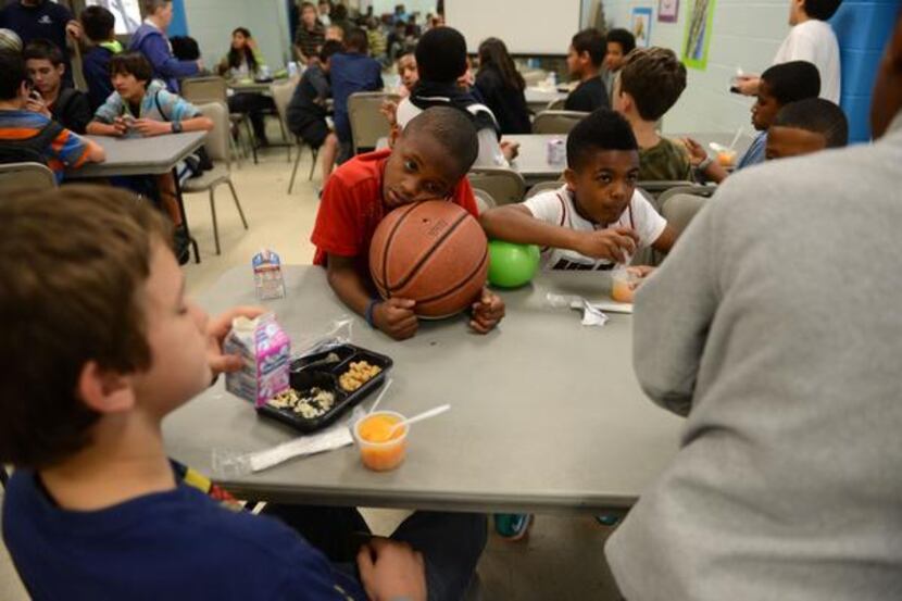 D.J. Baptiste, 10, rests his head on a basketball during snack time at the Boys and Girls...