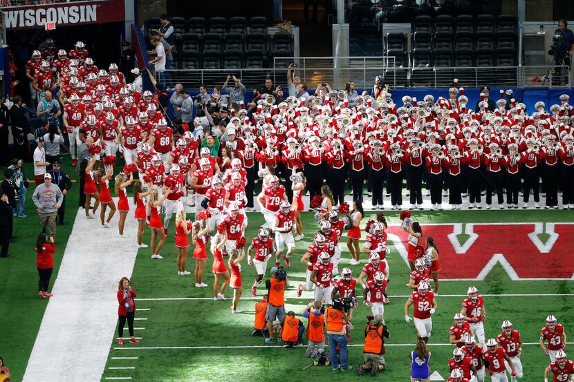 The Wisconsin Badgers football team is led onto the field by the cheerleaders before facing...