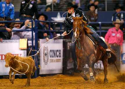 Tie-down roper Timber Moore of Aubrey lassos his calf during the American Rodeo qualifying...