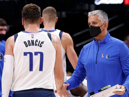 Dallas Mavericks assistant coach Igor Kokoskov (right) slaps hands with guard Luka Doncic...