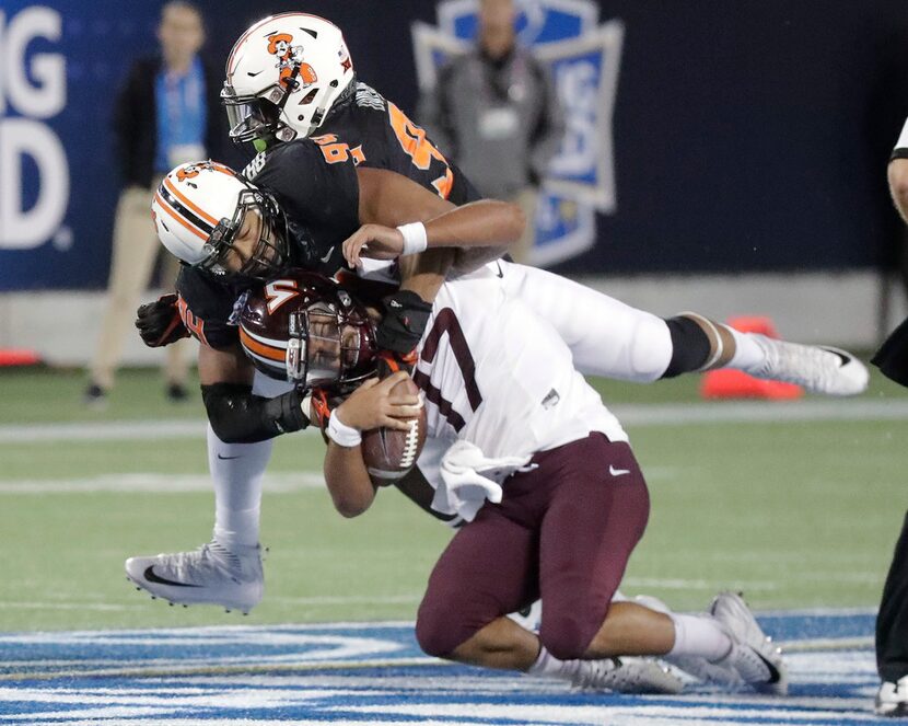 Oklahoma State defensive end Jordan Brailford, center, sacks Virginia Tech quarterback Josh...